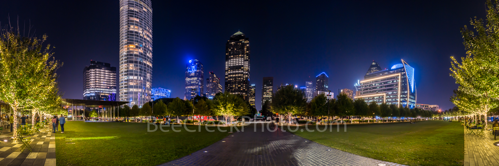 Klyde Warren Park Night Pano - Klyde Warren Park at night with the Dallas Skyline and the trees lighted in the park. The Klyde...